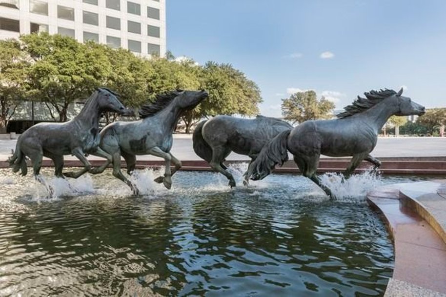 Group of horse sculptures in an open landscape