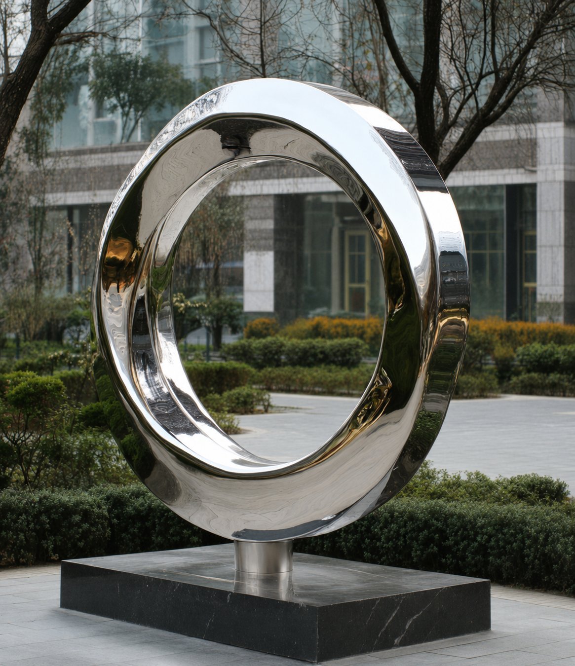 Large sculptural ring installed in a landscaped setting